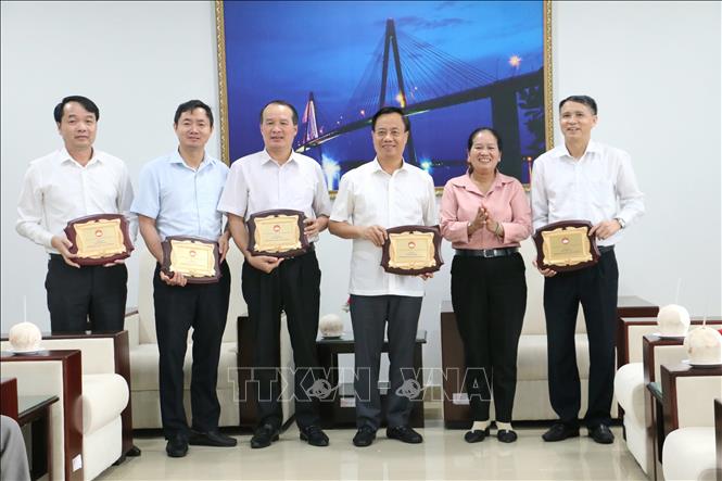 Phó Chủ tịch Ủy ban MTTQ Việt Nam tỉnh Bến Tre Đặng Thị Phượng trao biểu trưng tri ân tấm lòng vàng cho Ủy ban MTTQ Việt Nam tỉnh Bắc Giang. Ảnh: Chương Đài  - TTXVN 