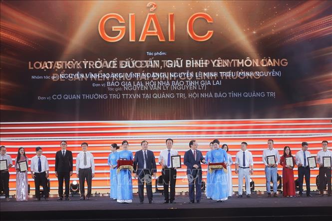 Tổng Biên tập Tạp chí Cộng sản Hoàng Trung Dũng và Tổng Giám đốc Đài Tiếng nói Việt Nam Đỗ Tiến Sỹ trao giải C cho các tác giả, nhóm tác giả đoạt giải. Ảnh: Minh Quyết - TTXVN