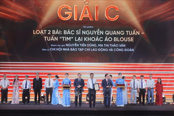 Tổng Biên tập Tạp chí Cộng sản Hoàng Trung Dũng và Tổng Giám đốc Đài Tiếng nói Việt Nam Đỗ Tiến Sỹ trao giải C cho các tác giả, nhóm tác giả đoạt giải. Ảnh: Minh Quyết - TTXVN