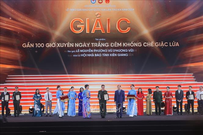 Tổng giám đốc TTXVN Vũ Việt Trang và Thứ trưởng Thường trực Bộ Văn hóa, Thể thao và Du lịch Lê Hải Bình trao giải C cho các tác giả, nhóm tác giả đoạt giải. Ảnh: Minh Quyết - TTXVN