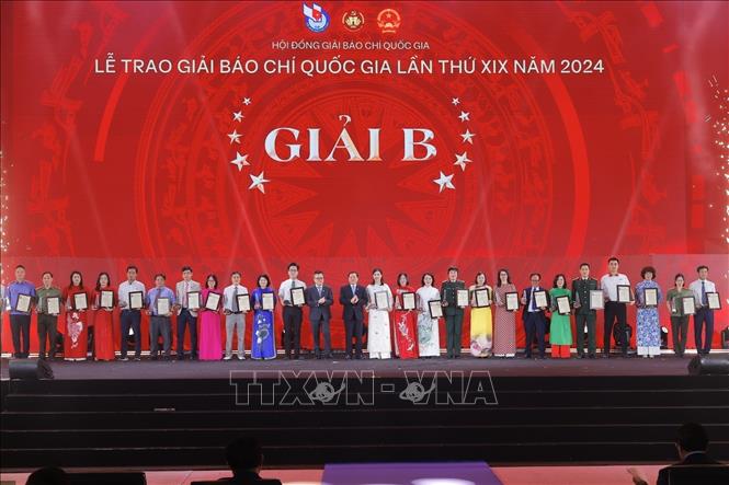 Phó trưởng Ban thường trực Ban Tuyên giáo và Dân vận Trung ương Lại Xuân Môn và Chủ tịch Hội Nhà báo Việt Nam, Tổng Biên tập Báo Nhân Dân Lê Quốc Minh trao giải B cho các tác giả, nhóm tác giả đoạt giải. Ảnh: Minh Quyết - TTXVN