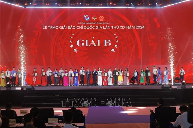 Phó trưởng Ban thường trực Ban Tuyên giáo và Dân vận Trung ương Lại Xuân Môn và Chủ tịch Hội Nhà báo Việt Nam, Tổng Biên tập Báo Nhân Dân Lê Quốc Minh trao giải B cho các tác giả, nhóm tác giả đoạt giải. Ảnh: Minh Quyết - TTXVN