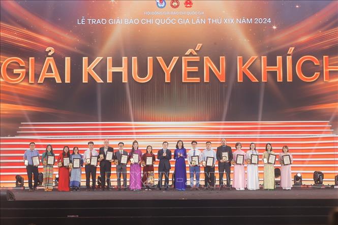 Ban tổ chức trao giải Khuyến khích cho tác giả, nhóm tác giả đạt giải. Ảnh: Minh Quyết - TTXVN