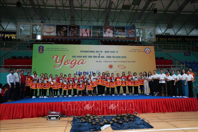 Đại diện Lãnh sự quán Ấn Độ tại Thành phố Hồ Chí Minh, Liên đoàn Yoga tỉnh Bình Dương cùng Ban tổ chức trao cờ lưu niệm cho các Câu lạc bộ tham gia sự kiện. Ảnh: Huỳnh Sơn-TTXVN