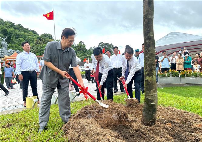 Nguyên Ủy viên Bộ Chính trị, nguyên Thủ tướng Chính phủ Nguyễn Tấn Dũng và Bí thư Tỉnh ủy Kiên Giang Nguyễn Tiến Hải (giữa) trồng cây lưu niệm tại Đền tưởng niệm Anh hùng liệt sĩ tại huyện Hòn Đất. Ảnh: Văn Sĩ - TTXVN 

