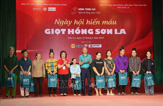 Tặng quà cho đại diện các gia đình chính sách, người có hoàn cảnh khó khăn. Ảnh: Quang Quyết - TTXVN