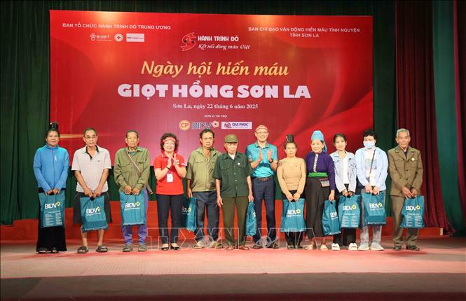 Tặng quà cho đại diện các gia đình chính sách, người có hoàn cảnh khó khăn. Ảnh: Quang Quyết - TTXVN