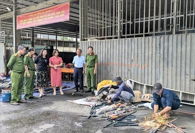 Công an tỉnh An Giang giám sát việc tiêu hủy công cụ hỗ trợ, vũ khí thô sơ. Ảnh: TTXVN phát