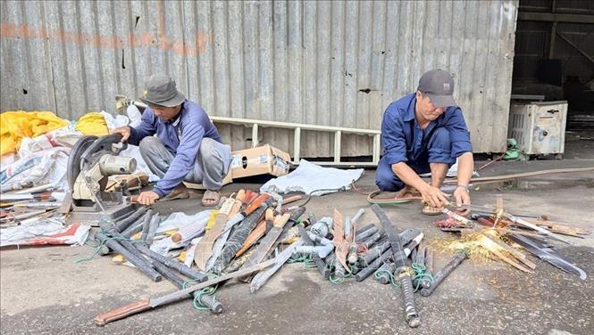 Tiêu hủy công cụ hỗ trợ, vũ khí thô sơ. Ảnh: TTXVN phát