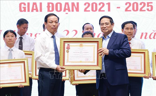 Thủ tướng Phạm Minh Chính trao Huân chương Lao động hạng Ba cho Đảng bộ, chính quyền và nhân dân huyện có thành tích xuất sắc trong Phong trào thi đua “Cả nước chung tay xây dựng nông thôn mới”. Ảnh: Dương Giang-TTXVN