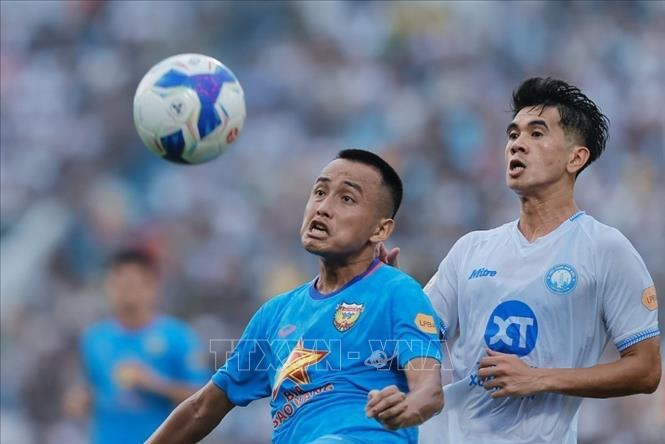 Pha tranh cướp bóng giữa cầu thủ Trần Văn Kiên (số 13, Nam Định) và cầu thủ bên phía HLHT. Ảnh: Minh Quyết - TTXVN
