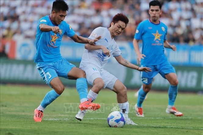 Pha tranh cướp bóng giữa càu thủ Tuấn Anh (số 11, Nam Định) và hậu vệ bên phía HLHT). Ảnh: Minh Quyết - TTXVN