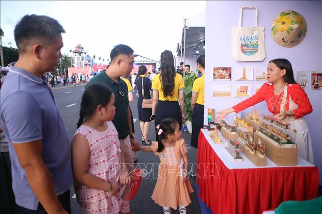 Giới thiệu các sàn phẩm lưu niệm của Đà Nẵng với du khách tại chương trình Giao lưu. Ảnh: Trần Lê Lâm - TTXVN 