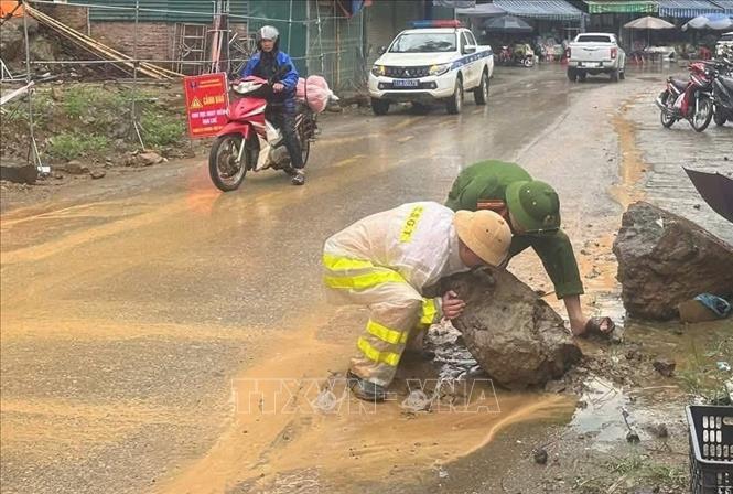 Cảnh sát giao thông huyện Bảo Lạc khắc phục hiện tượng sạt lở đất đá do mưa lớn, tạo thuận lợi cho người tham gia lưu thông. Ảnh: TTXVN phát
