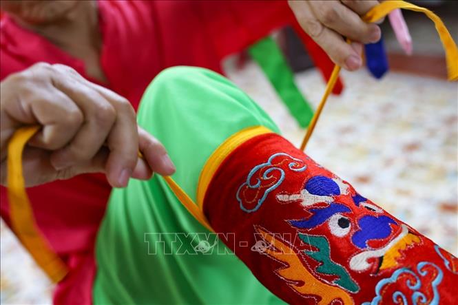 Phía sau sân khấu, mỗi bộ trang phục được mặc lên là một lần khoác lên mình trách nhiệm và niềm tự hào với văn hóa cung đình. Ảnh: Thanh Tùng - TTXVN 