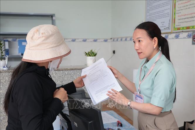 Hướng dẫn người dân làm thủ tục hành chính tại Trung tâm phục vụ hành chính công xã Đa Kia (mới). Ảnh: TTXVN phát
