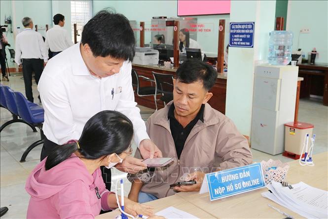 Hướng dẫn người dân thực hiện các bước làm thủ tục hành chính tại Trung tâm phục vụ hành chính công xã Bù Đăng (mới). Ảnh: TTXVN phát