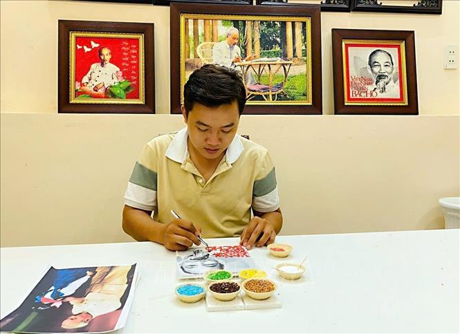 Anh Khưu Tấn Bửu (sinh năm 1995), chủ mô hình khởi nghiệp tranh gạo Tấn Bửu hoàn thiện tác phẩm tranh gạo về Chủ tịch Hồ Chí Minh. Ảnh: TTXVN phát