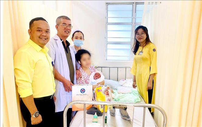 Nhân viên công tác xã hội Bệnh viện Hùng Vương Thành phố Hồ Chí Minh thăm hỏi, tặng quà cho một bé gái bị xâm hại mang thai và sinh con. Ảnh: TTXVN phát