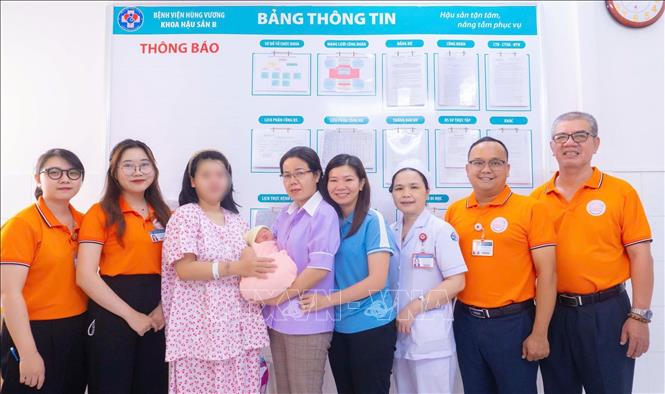 Nhân viên công tác xã hội Bệnh viện Hùng Vương Thành phố Hồ Chí Minh thăm hỏi, tặng quà cho một bé gái bị xâm hại mang thai và sinh con. Ảnh: TTXVN phát