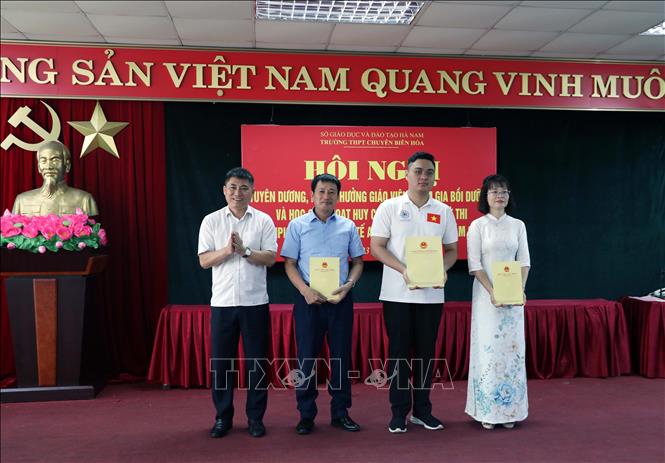 Giám đốc Sở Giáo dục và Đào tạo Hà Nam Phạm Anh Tuấn tặng Giấy khen và trao thưởng cho em Đỗ Trung Kiên và cô giáo Đinh Thị Xoan, thầy giáo Vũ Trường Giang. Ảnh: Đại Nghĩa - TTXVN