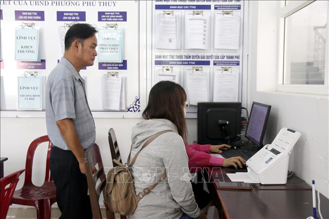 Hướng dẫn người dân kê khai thủ tục nộp hồ sơ trực tuyến tại bộ phận một cửa, phường Phú Thủy (Bình Thuận). Ảnh: Nguyễn Thanh - TTXVN
 
