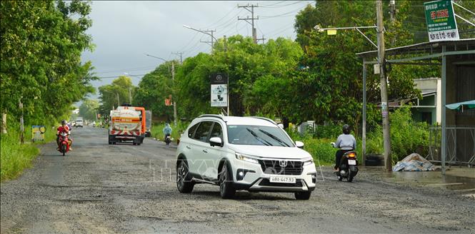 Đoạn Quốc lộ 61 từ cua Rạch Tìa đến cầu Bến Nhứt dài khoảng 8km mặt đường chi chít ổ gà, ổ voi. Ảnh: Văn Sĩ - TTXVN                                 