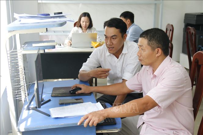 Hướng dẫn người dân kê khai thủ tục nộp hồ sơ trực tuyến tại bộ phận một cửa, phường Phú Thủy (Bình Thuận). Ảnh: Nguyễn Thanh - TTXVN