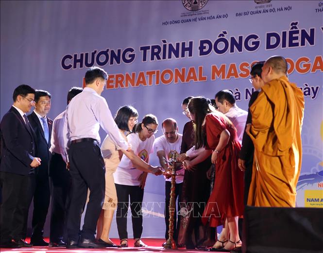 Đại biểu thực hiện nghi thức thắp nến khai mạc chương trình đồng diễn Yoga. Ảnh: Trần Lê Lâm - TTXVN