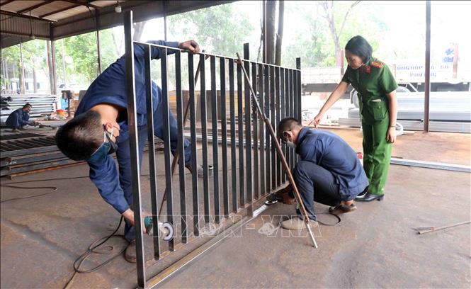 Các học viên được các cán bộ hướng dẫn lao động, học nghề. Ảnh: Phạm Kiên - TTXVN