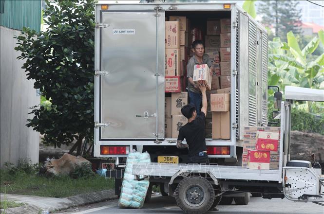 Hàng hóa với thương hiệu lạ từ làng La Phù tiếp tục được vận chuyển lên xe vận chuyển về các tỉnh thành khác. Ảnh: Thành Phương – TTXVN