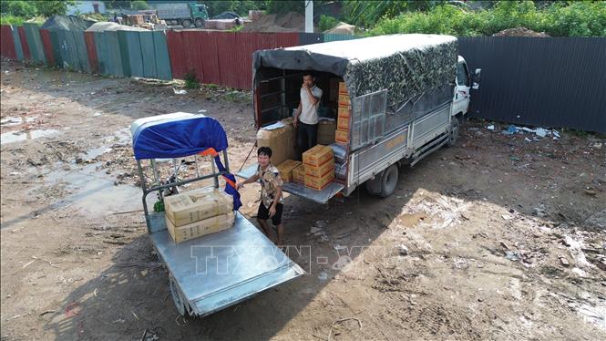 Các sản phẩm với nhiều thương hiệu lạ dành cho trẻ em được các xe tải lớn nhập hàng mỗi ngày vào làng La Phù. Ảnh: Thành Phương – TTXVN