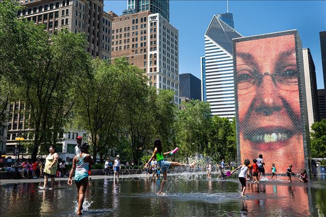 Người dân tránh nóng bên đài phun nước tại Chicago, Mỹ. Ảnh: THX/TTXVN
