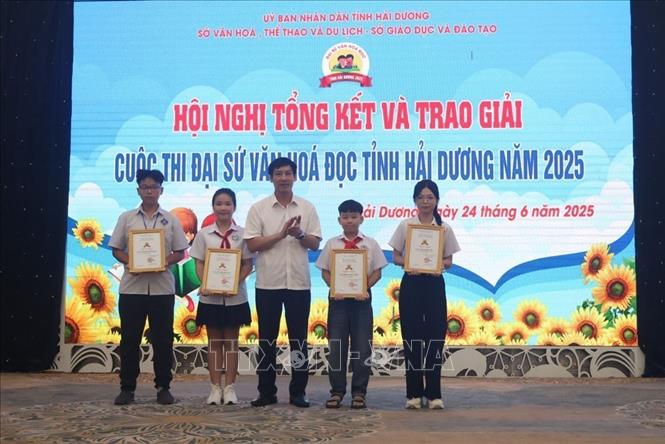 Phó Giám đốc Sở Văn hóa, Thể thao và Du lịch Hải Dương Nguyễn Trường Thắng, Trưởng Ban tổ chức cuộc thi, trao giải Nhất cho 4 học sinh. Ảnh: Mạnh Minh - TTXVN