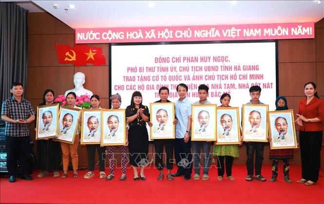 Lãnh đạo Công ty Cổ phần Cơ khí và Khoáng sản Hà Giang và huyện Bắc Mê trao tặng ảnh Bác Hồ cho các hộ dân xóa nhà tạm và các xã mới thành lập. Ảnh: TTXVN phát