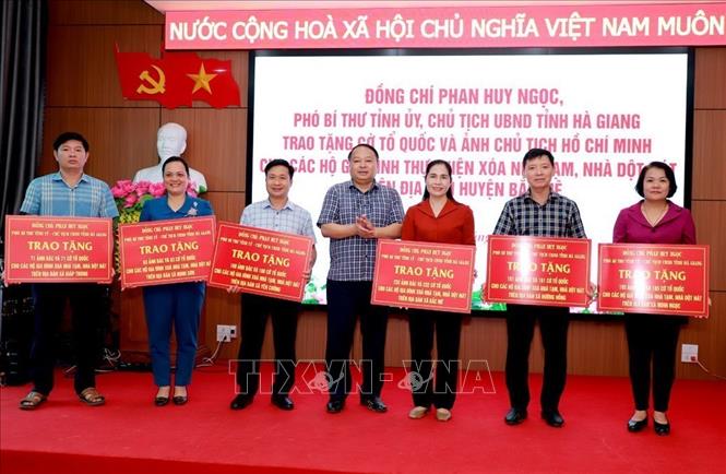 Chủ tịch UBND tỉnh Hà Giang Phan Huy Ngọc trao biểu trưng Cờ Tổ quốc và ảnh Chủ tịch Hồ Chí Minh cho lãnh đạo 6 xã mới sau sáp nhập của huyện Bắc Mê. Ảnh: TTXVN phát