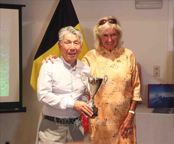 Bà Chris Geyskens, Chủ tịch Chi nhánh Bỉ của Hội quốc tế nạn nhân chất độc da cam Việt Nam - Hội An, trao tặng phần thưởng cho người đoạt giải. Ảnh: Hương Giang - PV TTXVN tại Bỉ