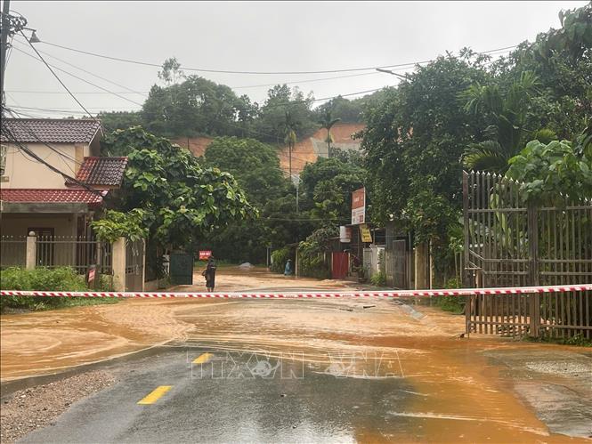 Các đơn vị chức năng căng dây không cho phương tiện lưu thông qua Khu vực ngã 3 đường Khe Sến (Yên Bái) bị ngập sâu. Ảnh: Đinh Thùy-TTXVN