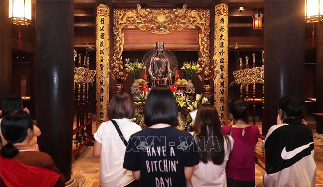 Phụ huynh và học sinh đến khu Thái học, nơi đặt tượng Tư nghiệp Quốc Tử Giám Chu Văn An dâng hương cầu may trước kỳ thi. Ảnh: Thành Phương - TTXVN
