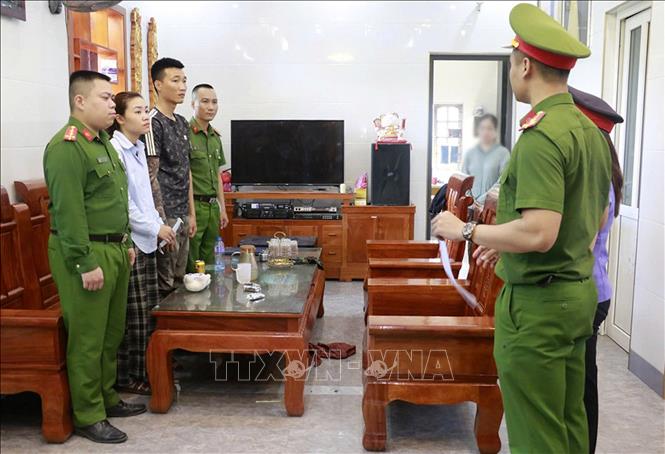 Cơ quan chức năng đọc lệnh khám xét nơi ở của 2 đối tượng Phan Đình Thịnh (sinh năm 1995) và Lê Thị Trà (sinh năm 1999) cùng trú tại xã Hưng Đạo (Hưng Nguyên, Nghệ An) là 2 trong những đối tượng cầm đầu đường dây. Ảnh: TTXVN phát