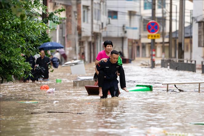 Lực lượng cứu hộ hỗ trợ người dân sơ tán khỏi khu vực ngập lụt tại huyện Tòng Giang, tỉnh Quý Châu, Trung Quốc ngày 24/6/2025. Ảnh: THX/TTXVN