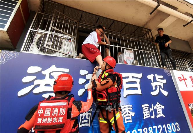 Lực lượng cứu hộ hỗ trợ người dân sơ tán khỏi khu vực ngập lụt tại huyện Dung Giang, tỉnh Quý Châu, Trung Quốc ngày 24/6/2025. Ảnh: THX/TTXVN