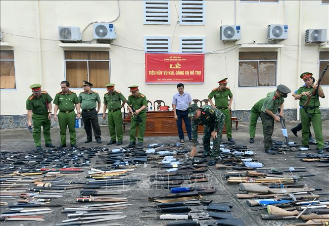 Các thành viên Hội đồng tiêu hủy kiểm tra các loại vũ khí, công cụ hỗ trợ. Ảnh: Trọng Nguyễn - TTXVN