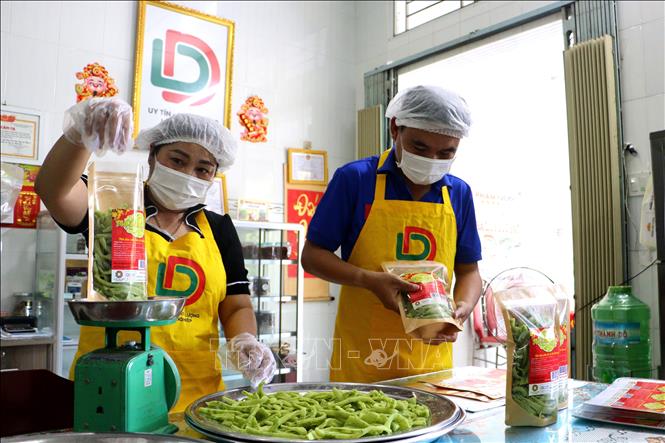 Đóng gói sản phẩm mứt dừa lá dứa, sản phẩm OCOP của huyện Vũng Liêm (Vĩnh Long). Ảnh: Lê Thúy Hằng – TTXVN 
