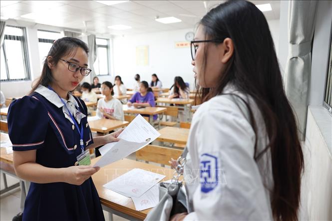 Kiểm tra thông tin của thí sinh trước khi vào phòng thi, nghe phổ biến quy chế tại điểm thi trường THCS Xuân La, quận Tây Hồ. Ảnh: Thanh Tùng - TTXVN 