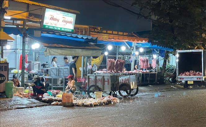 Chế biến và bày bán thịt lợn ngay trên nền đất tại đường N4 đối diện chợ đầu mối nông sản thực phẩm Hóc Môn (Thành phố Hồ Chí Minh). Ảnh: Hương Giang - TTXVN
