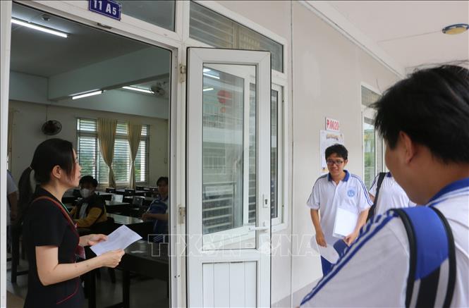 Thí sinh tại điểm thi Trường THPT Long Xuyên (thành phố Long Xuyên) được giám thị gọi vào phòng thi làm thủ tục. Ảnh: Công Mạo-TTXVN