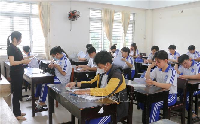 Thí sinh tại điểm thi Trường THPT Long Xuyên đối chiếu thông tin cá nhân, đính chính thông tin sai sót (nếu có) và nghe phổ biến quy chế thi, lịch thi. Ảnh: Công Mạo-TTXVN