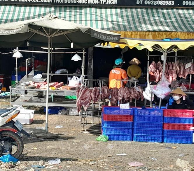 Thịt lợn tại chợ tự phát gần chợ đầu mối nông sản thực phẩm Hóc Môn được bày bán không đảm bảo điều kiện vệ sinh. Ảnh: Hương Giang - TTXVN