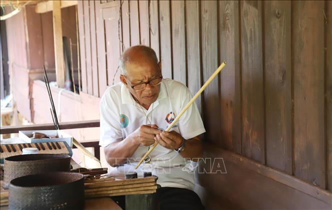 Ông Buavanh Oudomsuk làm công đoạn khoét lỗ Khèn. Ảnh: Xuân Tú - PV TTXVN tại Lào